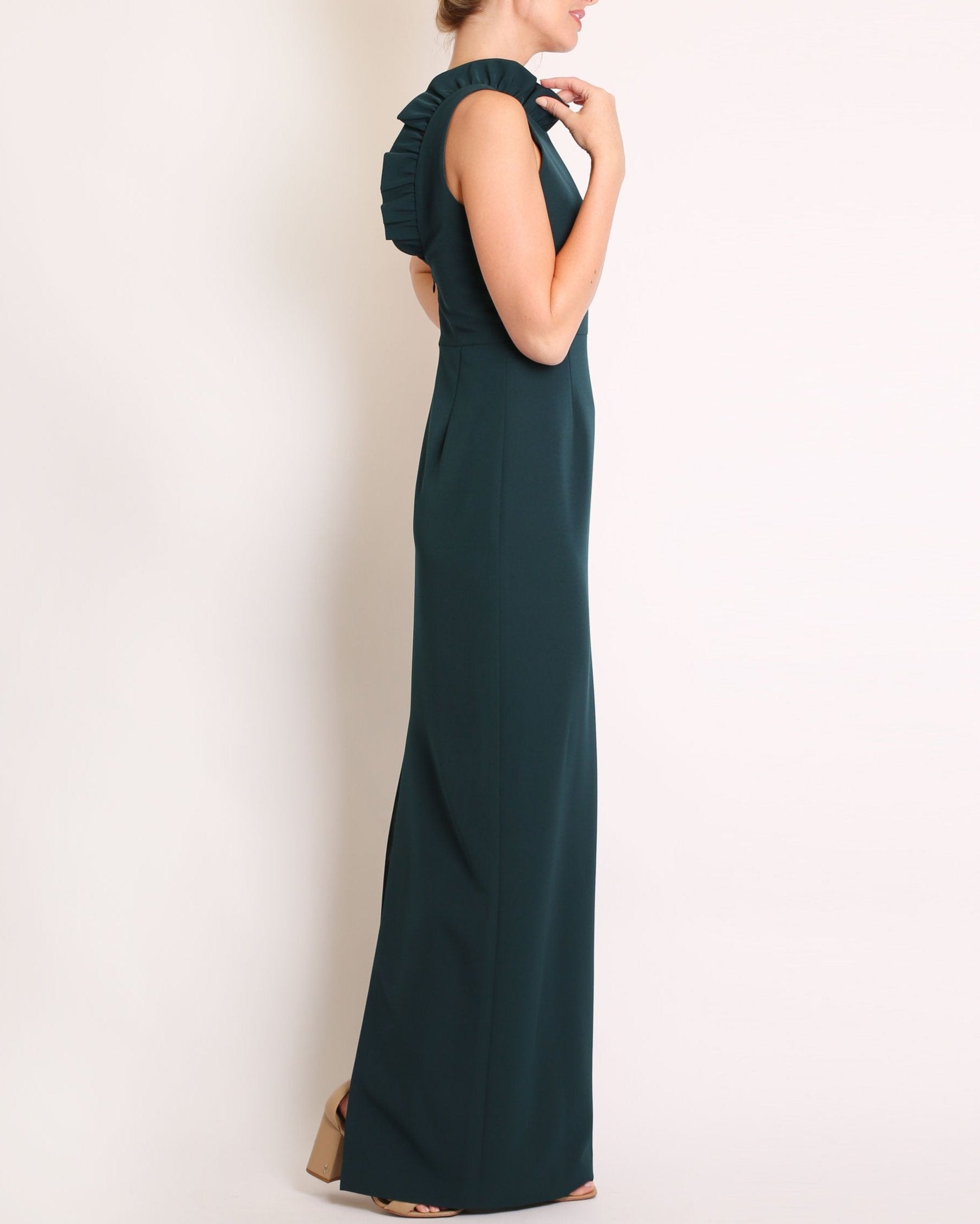 A floor-length sleeveless Evergreen gown with a ruffle neckline and a V-back detail, featuring a sheath silhouette made of stretch crepe fabric.