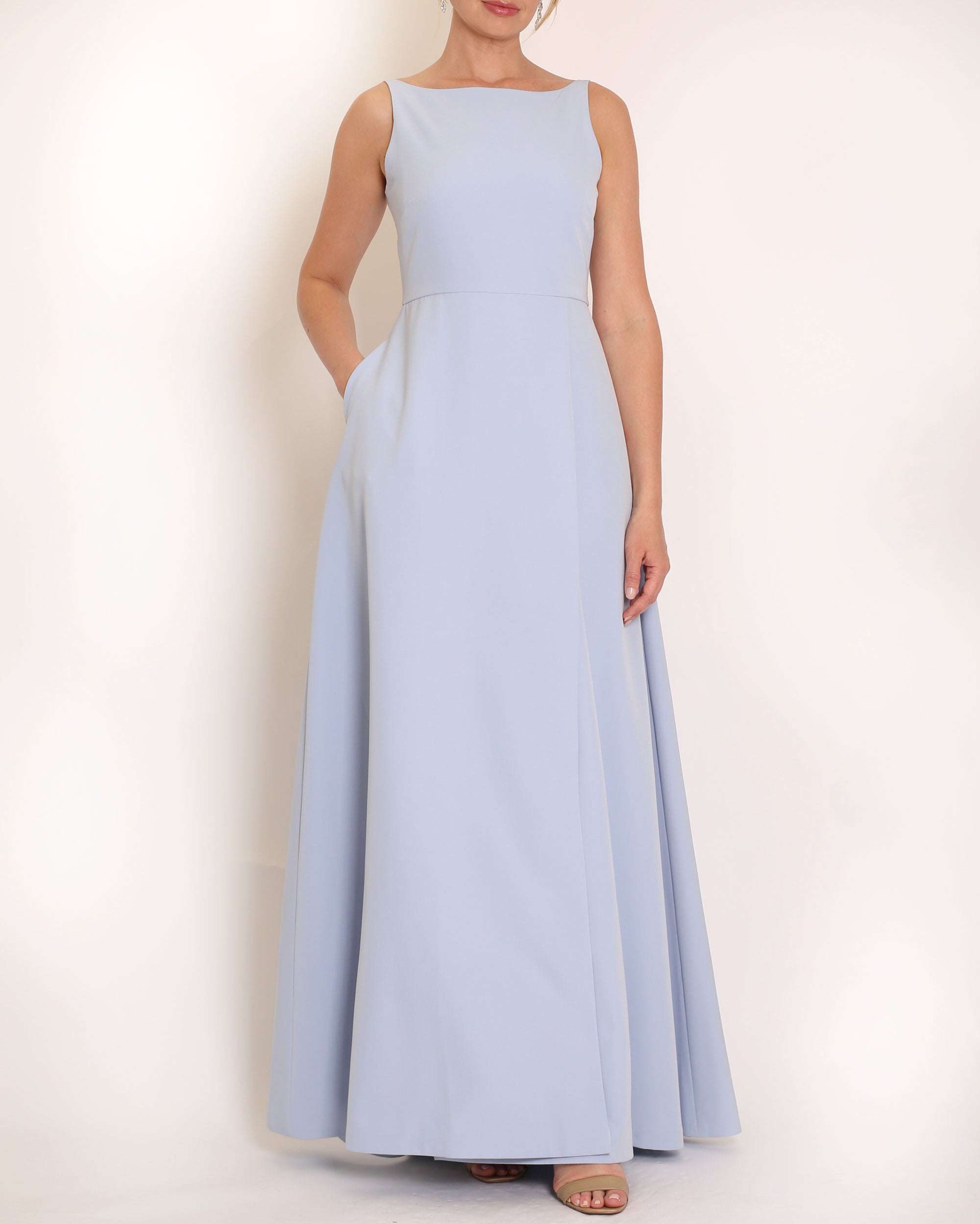 Light Blue floor length evening gown with boat neck detail and v-back. A-line flared skirt with front side slit and pockets.