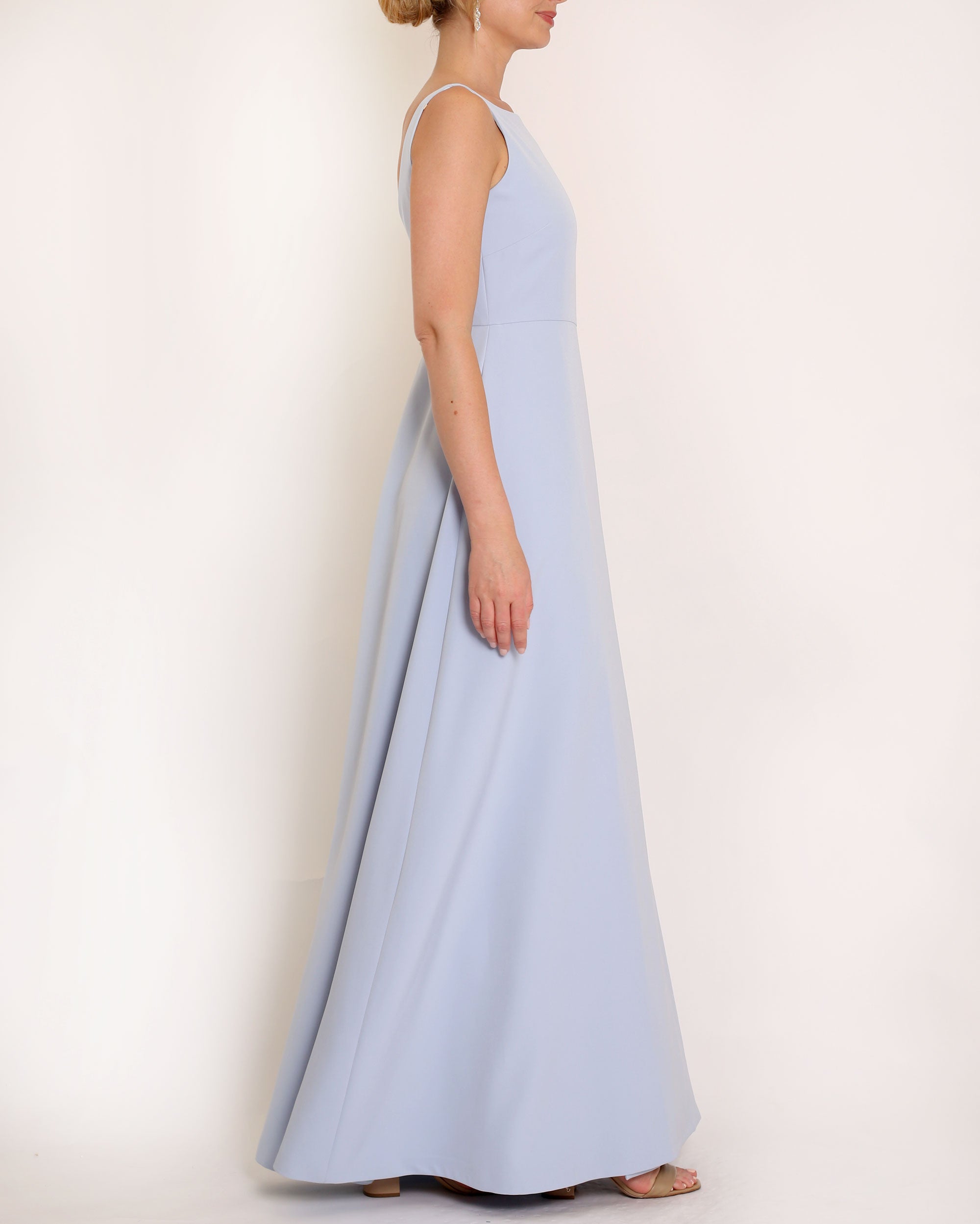 Light Blue floor length evening gown with boat neck detail and v-back. A-line flared skirt with front side slit and pockets.