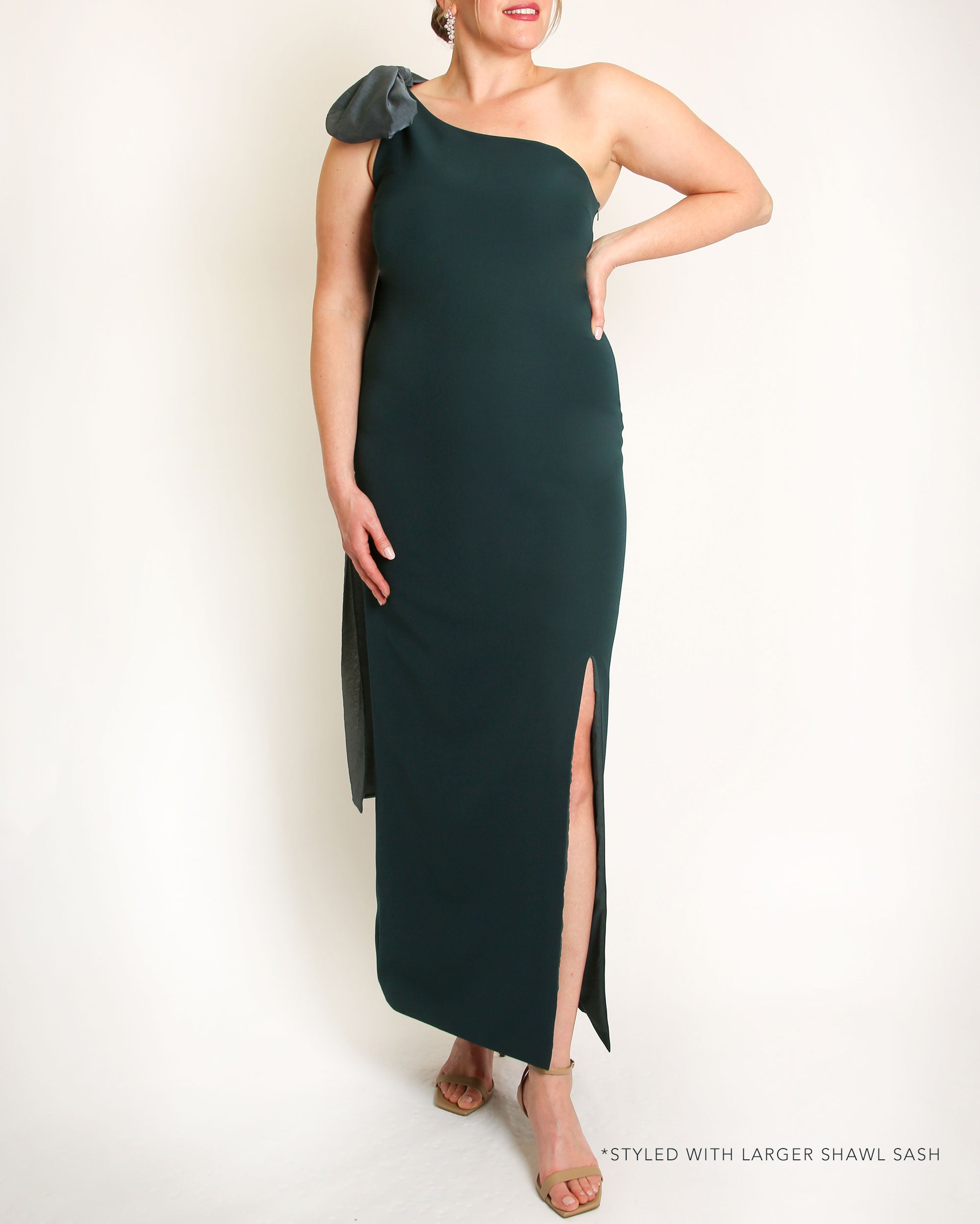 Evergreen one-shoulder gown with a large bow detail on a white background