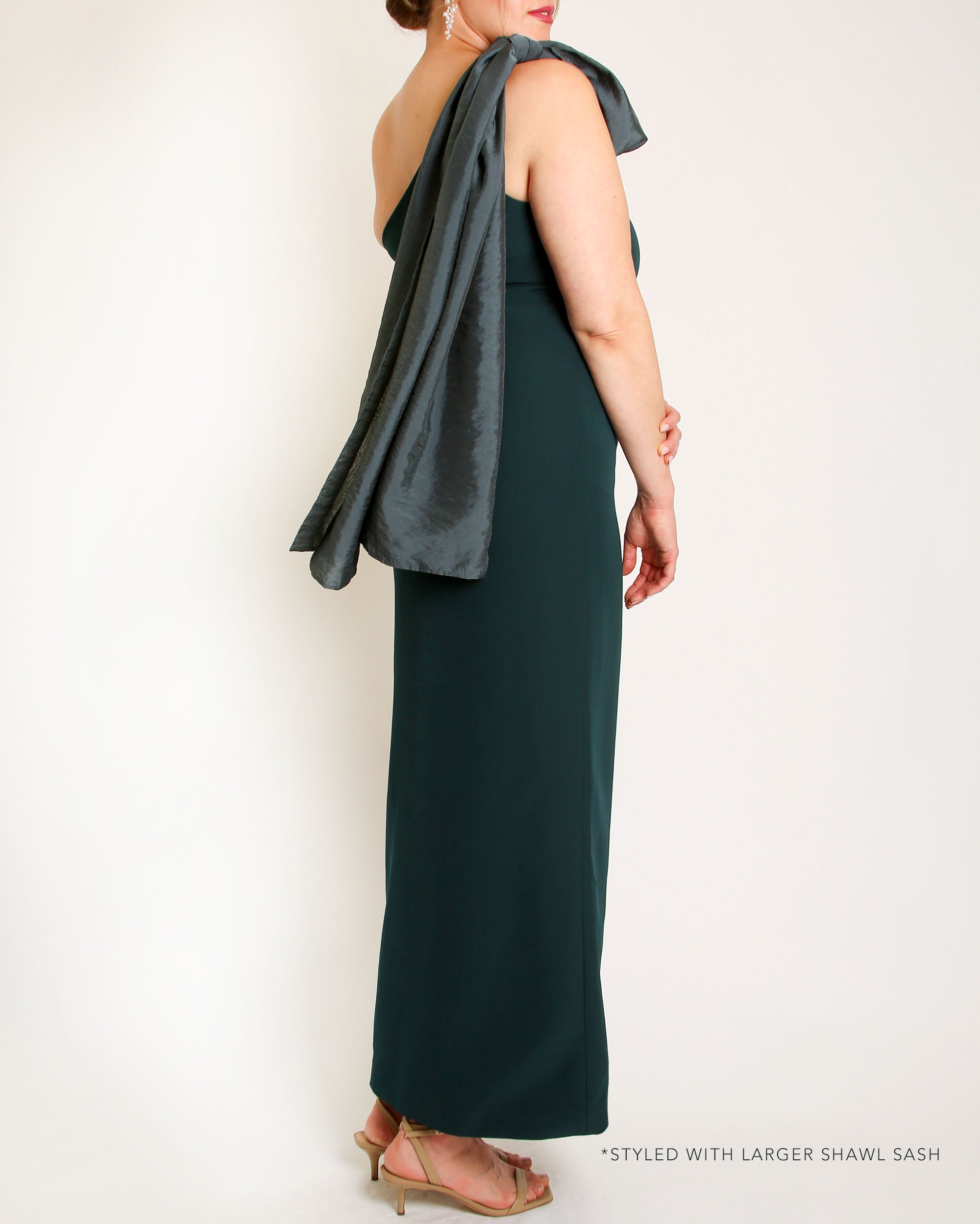 Evergreen one-shoulder gown with a large bow detail on a white background