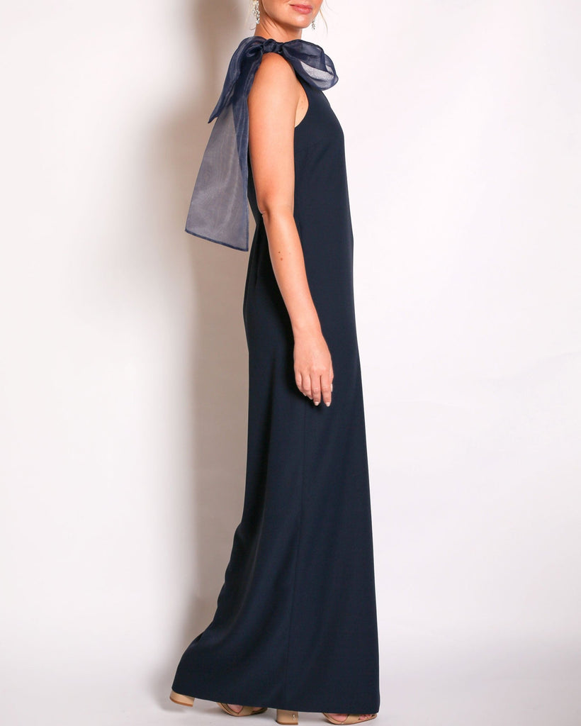 Navy one-shoulder gown with a large bow detail on a white background