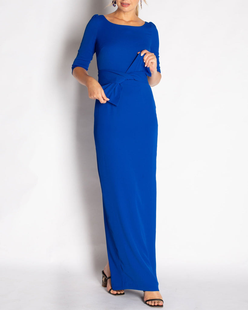 A Royal Blue floor length gown made in a stretch crepe material that is comfortable to wear. Elegant boat neck detail with 3/4 length sleeves. This dress waist line is at natural waist with a removable sash that can be styled with or without the gown.
